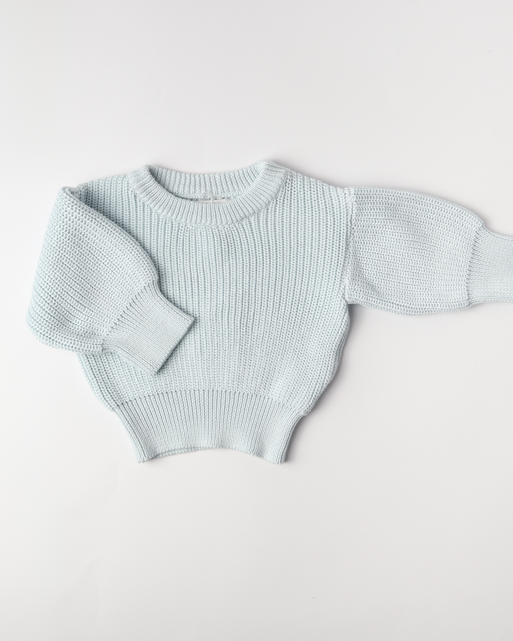 Light blue knitted sweater on a white background
