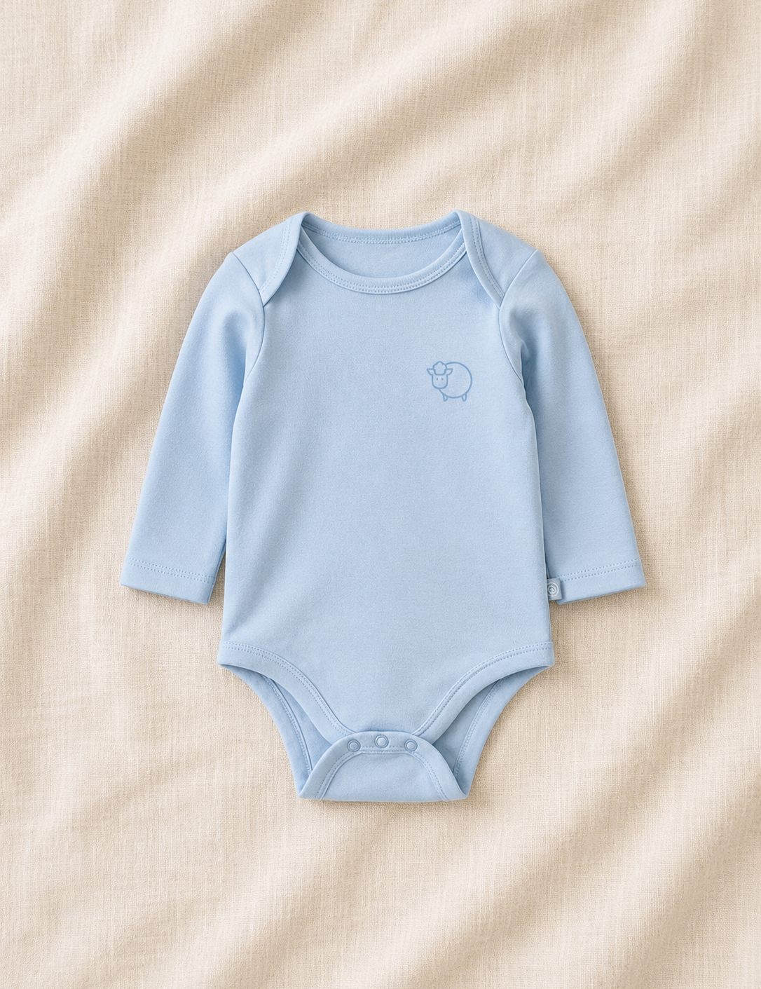 Blue baby bodysuit with a logo on a beige fabric background