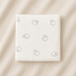 White product packaging with small icons on a beige fabric background