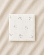 White product packaging with small icons on a beige fabric background